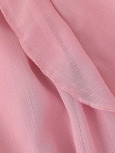 Dettaglio ravvicinato della trama del tessuto chiffon rosa e della finitura dei bordi
