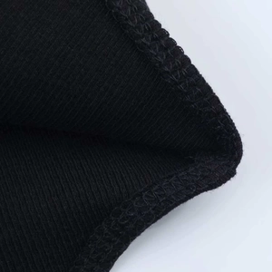Close-up of black ribbed knit fabric with precise edge stitching and vertical texture