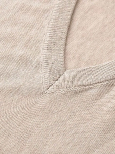 Close-up detail of the elegant V-neckline on a beige soft knit sweater for women