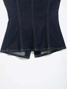 Detailed macro view of dark blue denim hem with contrast stitching and seam detail