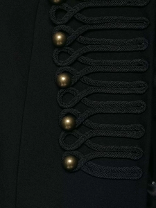 Dettaglio di alamari intrecciati vintage e bottoni in bronzo sulla giacca nera