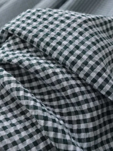 Gros plan sur le tissu vichy vert et blanc à texture naturelle pour robes midi