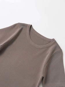 Detailed view of the ribbed knit fabric and crew neckline on a brown short sleeve top