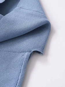 Close-up of the light blue knitted fabric showing the neat side slit and detailed texture