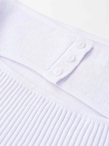 Détail macro du tricot lavande avec texture côtelée et trois petits boutons blancs