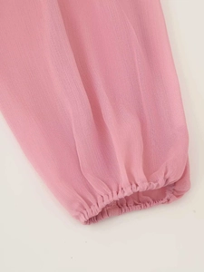Dettaglio dell'abito in chiffon rosa con polsini elastici e design a manica a lanterna