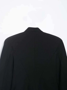 Dettaglio della giacca corta nera con cuciture curve sul retro e linee sartoriali curate