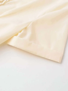Detailed close-up showing smooth beige fabric texture and premium stitching craftsmanship