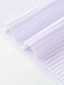 Gros plan détaillé du tissu en maille côtelée blanche montrant une texture douce et tissage fin