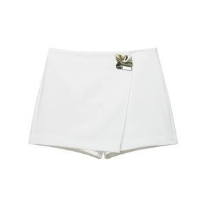 Detail of white skort featuring a side silver wavy metal buckle and wrap-over design