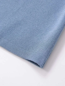 Macro detail of sky blue ribbed knit fabric showing fine texture and hem stitching