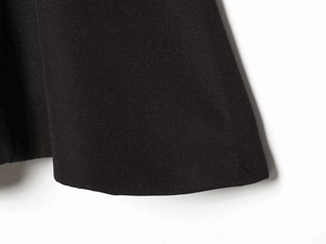 Makroaufnahme der sauberen Nähte und Webstofftextur am Saum eines schwarzen Neckholder-Tops