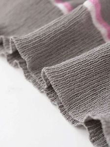 Dettaglio del tessuto a maglia grigio con strisce bianche e viola e trama a costine