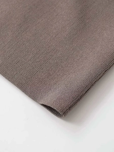 Detailed macro view of the brown ribbed knit fabric and high-quality sewing finish