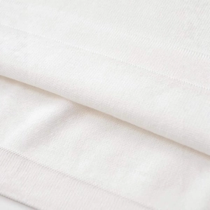 Close-up of white knit short-sleeve sweater showing detailed ribbed hem and soft fabric texture