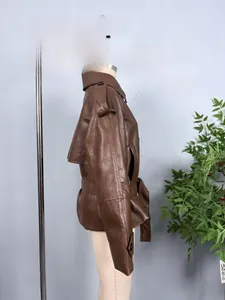 Detail view of dark brown faux leather jacket with waist belt and epaulette design