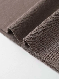 Close-up of fine brown knit fabric showing detailed vertical ribbed cuff and smooth texture