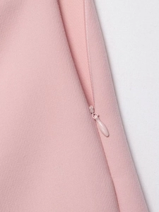 Detail of invisible zipper on pink asymmetrical skort showing high-quality fabric texture