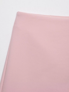 Close-up of high-density light pink fabric texture and fine stitching on asymmetric skort