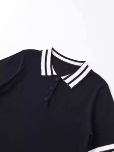Detail of black knit polo shirt showing collar with contrast stripes and fabric texture
