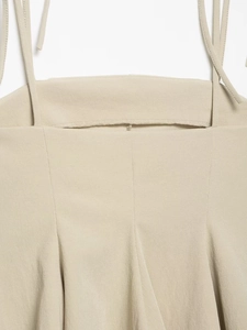 Detail of the thin straps and stitched seams on a beige summer camisole top