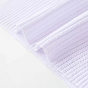 Dettaglio della texture in maglia a costine bianca per maglione con spalle scoperte