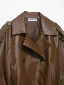 Detailed view of dark brown faux leather jacket with classic lapels and vintage texture