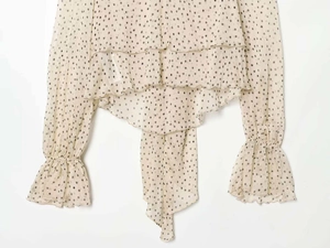Detailed view of polka dot chiffon blouse featuring tiered ruffles and elasticated cuffs