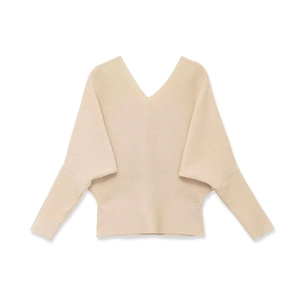 Detail of cream V-neck knit sweater featuring soft ribbed texture and batwing sleeves