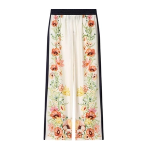 Close-up of high-waisted wide-leg trousers with floral print and blue side stripes