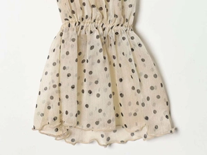 Detailed close-up of polka dot chiffon fabric with pleated texture and elastic waist