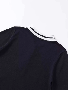 Detail of black knit top featuring a striped ribbed collar with delicate scalloped edges
