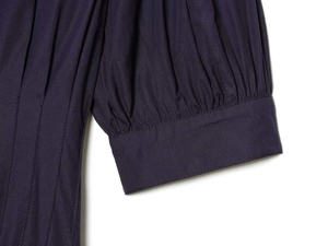 Détail de la robe midi en popeline bleu marine avec plis verticaux et coutures aux manches