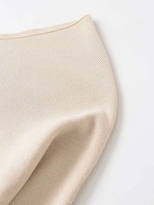Detail of minimalist beige knit fabric with fine stitching and soft texture