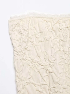 Detail shot of cream white tube top featuring 3D embossed texture and delicate lace trim