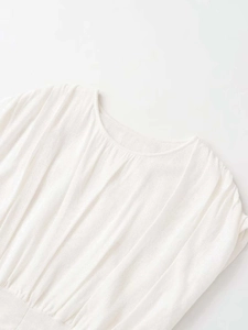 Close-up of a white sleeveless knit top with sun pleats and a classic round neckline