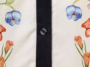 Macro detail of floral print shirt featuring a black placket and contrast button