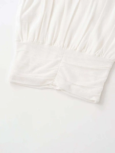 Detail of white sleeveless knit tank top featuring a stylish ruched elastic waist design