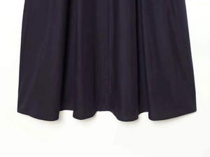 Détail de la couture de l'ourlet et du tissu en popeline bleu marine de la robe midi