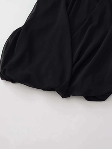Detailed macro view of the black chiffon blouse featuring pleated bubble hem design