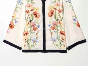 Close-up of floral print shirt with black contrast trim and buttons on the cuff