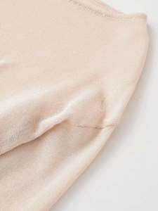 Close-up of beige knit fabric showing high-density texture and breathable mesh detail
