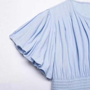 Elegant light blue short sleeve shirt featuring puff sleeves and textured pleated details