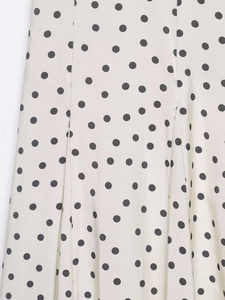 Gros plan détaillé sur un tissu à pois blanc cassé léger avec texture mate fine
