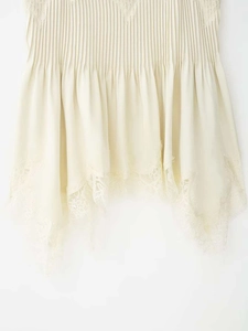 Detailed shot of pleated hem featuring exquisite eyelash lace and irregular ruffle design