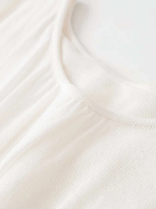 Detailed macro view of the white knitted neckline showing fine ribbing and soft texture