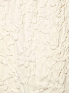 Detailed macro view of the cream popcorn fabric with 3D pleated texture and stretch grain