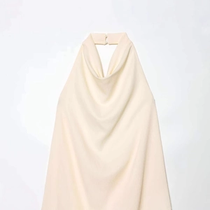 Top minimalista beige con scollo all'americana, bottoni posteriori e tessuto leggero