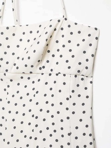 Détails du tissu blanc à pois et des fines bretelles de cette robe midi d'été élégante