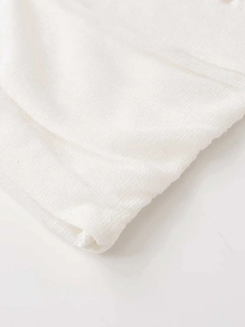 Close-up of the high-quality white knitted fabric texture and refined hem stitching detail
